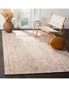 an area rug with a chair and vase on the floor