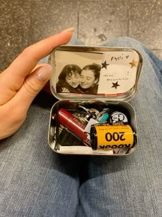 a person holding an open tin with personalized items in it