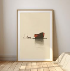 a red boat sitting on top of a wooden floor next to a wall with a white frame