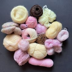 several skeins of yarn sitting on top of a black surface with different colors