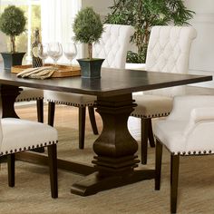 a dining room table with white chairs around it