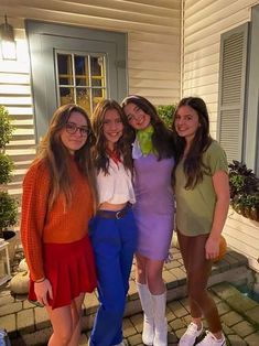 three girls are posing for the camera in front of a house