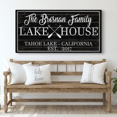 a wooden bench sitting in front of a white wall with the words lake house on it