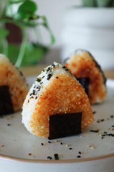 some kind of sushi on a plate with black sesame sprinkled around it