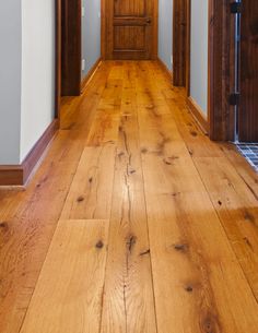 an empty hallway with wood floors and white walls