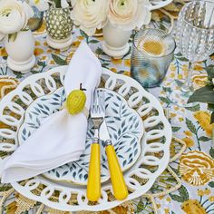 the table is set with yellow utensils and white napkins