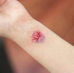 a woman's wrist with a small red flower on it