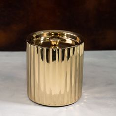 a gold metal container sitting on top of a white table