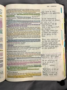 an open bible with many different colored words on it's pages and in the middle