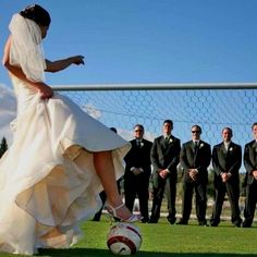 a woman in a wedding dress kicking a soccer ball