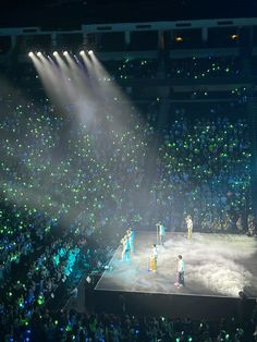 a group of people standing on top of a stage in front of a large crowd