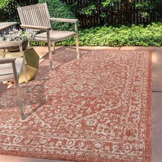 an outdoor area rug with chairs and table