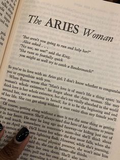 a person's hand holding an open book with the words the aris woman written on it