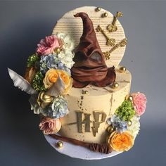 a cake decorated with flowers and a wizard hat