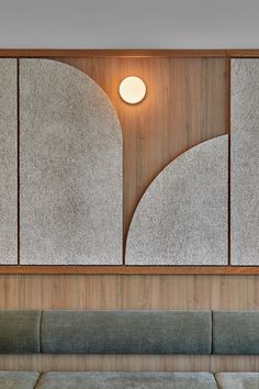 a couch and table in a room with wood paneling on the wall behind it