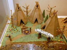 a cake made to look like native american teepees and people in the woods