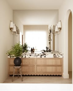 a bathroom with two sinks, mirrors and lights on the wall next to each other