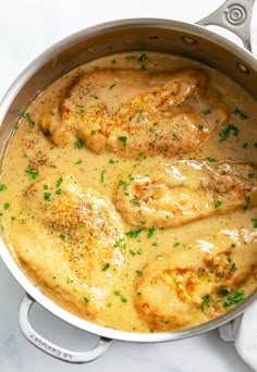 a pot filled with chicken and gravy on top of a white countertop