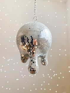 a disco ball shaped like an elephant hanging from a chain