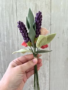 a person is holding some flowers in their hand