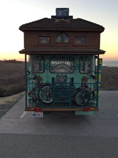 a small building with bicycles attached to the front and sides, sitting on top of a parking lot