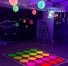 an illuminated dance floor with colorful lights in the background and disco balls hanging from the ceiling