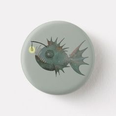 a green button with a fish on it's side and a yellow light at the end