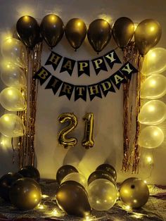 a birthday decoration with balloons and streamers in the shape of number twenty, surrounded by gold foil balls