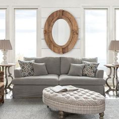 a living room filled with furniture and a round mirror