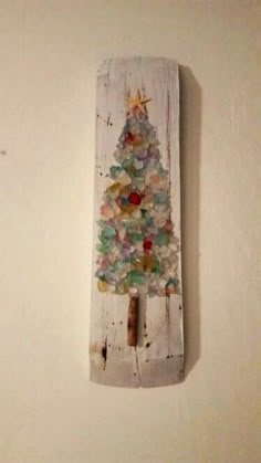 a small wooden christmas tree hanging on the wall