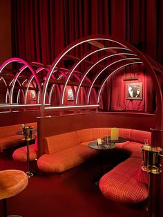 an empty restaurant with red walls and booths