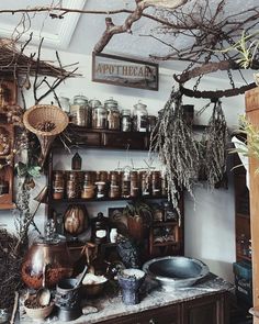 an old fashioned kitchen with lots of pots and pans on the shelves above it