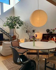 a living room filled with lots of furniture and a round white table surrounded by chairs