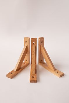 three pieces of wood sitting next to each other on a white surface with one piece missing