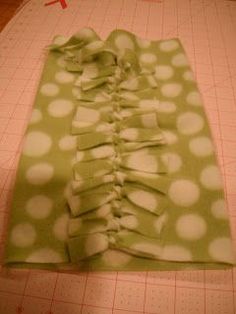 a green and white polka dot fabric on a cutting board