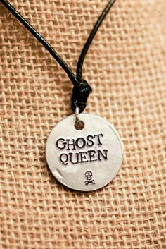 "One of my most popular necklace designs is my \"Ghost King\" necklace. I realized that not all children of Hades are guys, so I present to you the gender-bend of my original design. Here's my Percy Jackson inspired \"Ghost Queen\" necklace! PRODUCT INFORMATION: - Made on a 1 inch aluminum blank (wearer friendly) - Hangs on a black adjustable cord, about 26 inches at the largest setting - The words \"GHOST QUEEN\" and a skull are stamped on the pendant - Pendant made to look battered as if worn Pjo Necklace, Hades Necklace, Children Of Hades, King Necklace, Percy Jackson Outfits, Ghost King, Gender Bend, Queen Necklace, My Ghost