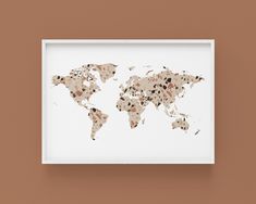 a framed map of the world is shown on a brown wall, with dots all over it