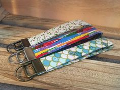 a pair of scissors are sitting on top of some fabric covered wallets that have been tied together