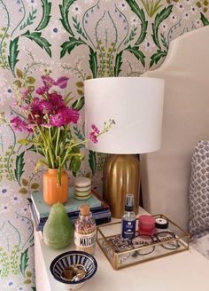 a table topped with vases filled with flowers next to a lamp