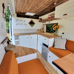 an orange couch sitting inside of a kitchen next to a stove top oven