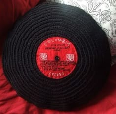 a close up of a red and black object on a bed