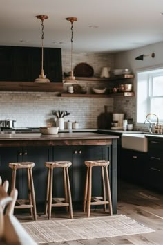 three stools are in front of the kitchen counter