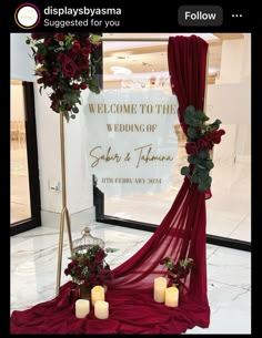 a red wedding arch decorated with flowers and candles for the entrance to the ceremony hall