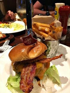 a bacon cheeseburger with french fries on the side