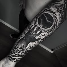 a man's arm with a black and white tattoo on it