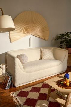 a living room filled with furniture and a fan on the wall above it's head