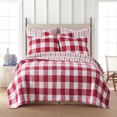 a red and white checkered comforter set on a bed