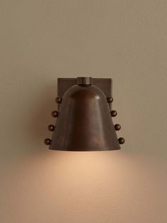 a light that is on the side of a wall with a brown lamp in front of it