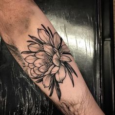 a black and white flower tattoo on the arm