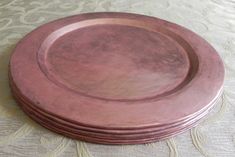 a stack of pink plates sitting on top of a table